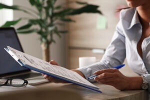 Unrecognizable businesswoman going through reports while working in the office.